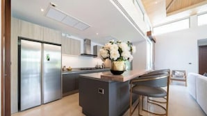 A modern kitchen with a central island, stainless steel appliances, and a vase of flowers.