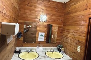 A wooden-paneled bathroom with two sinks, a mirror, and a soap dispenser. - FOREST GARDEN HOTEL (Oshino)