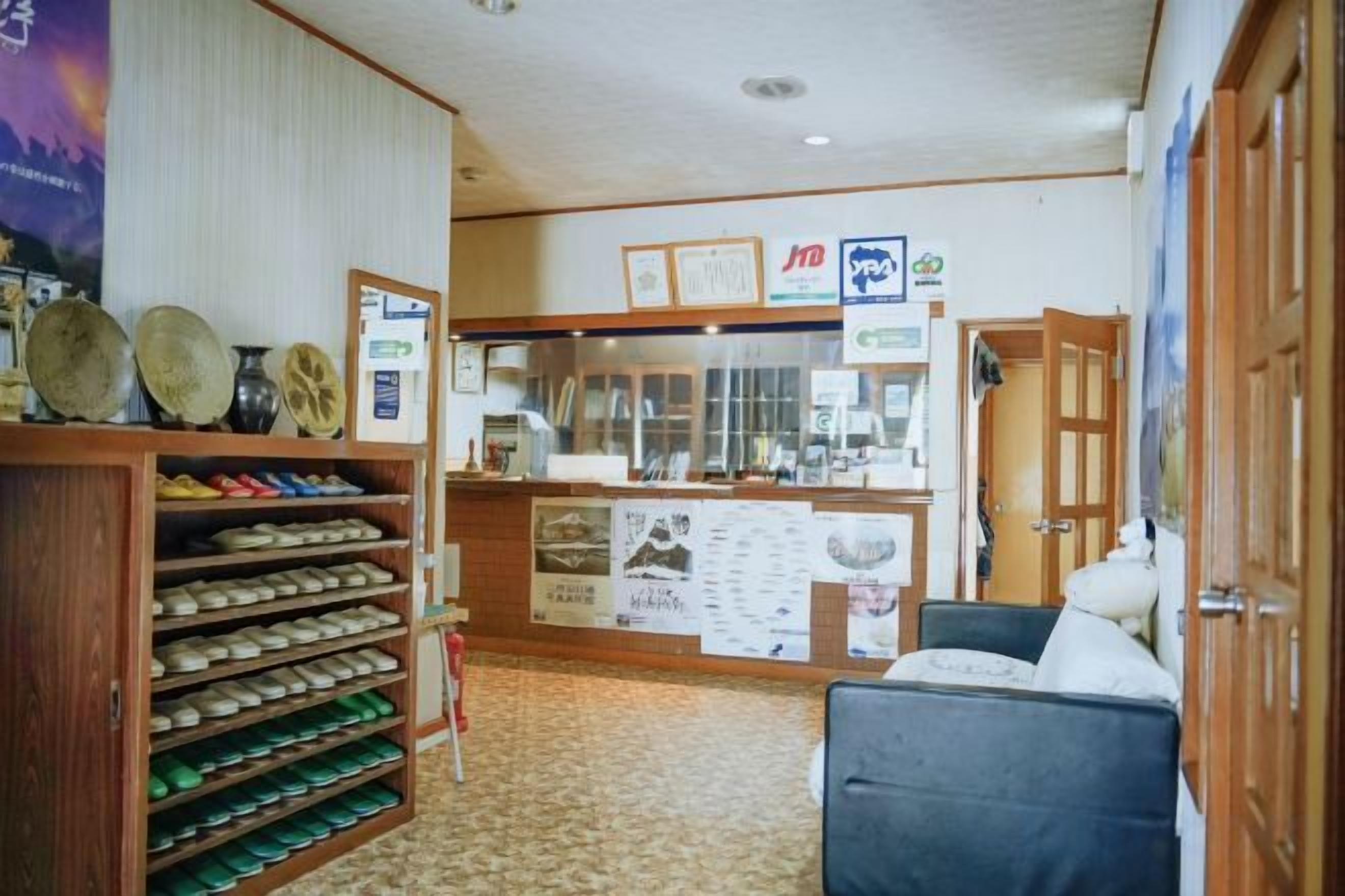 A hotel lobby with a reception desk, a shoe display, and a seating area.