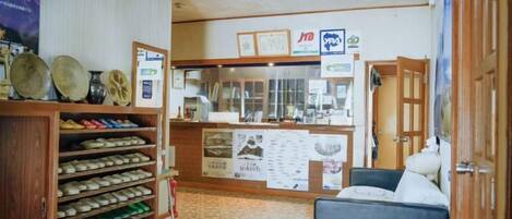 A hotel lobby with a reception desk, a shoe display, and a seating area.