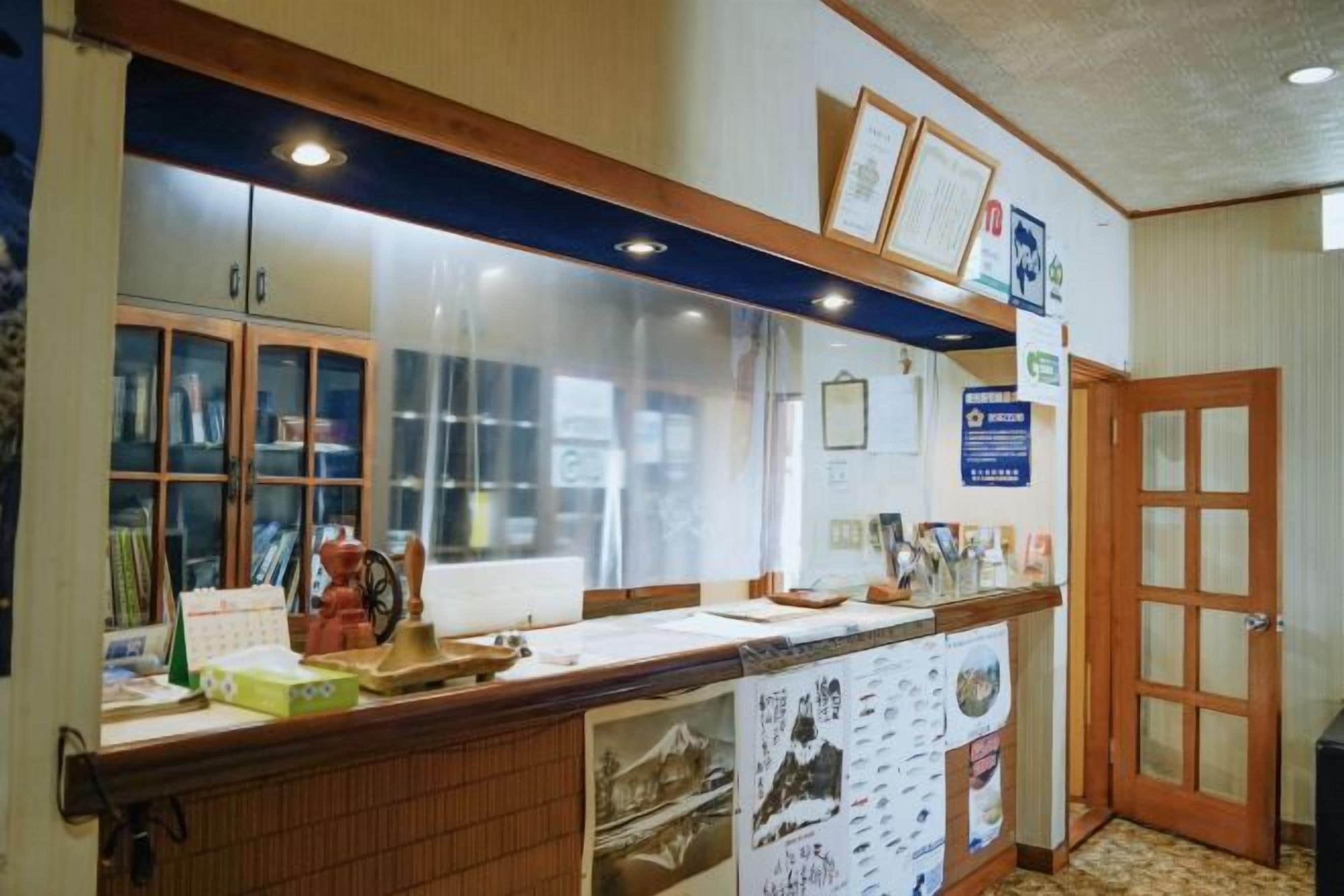 A reception desk with a wooden counter, glass display cases, and informational posters.