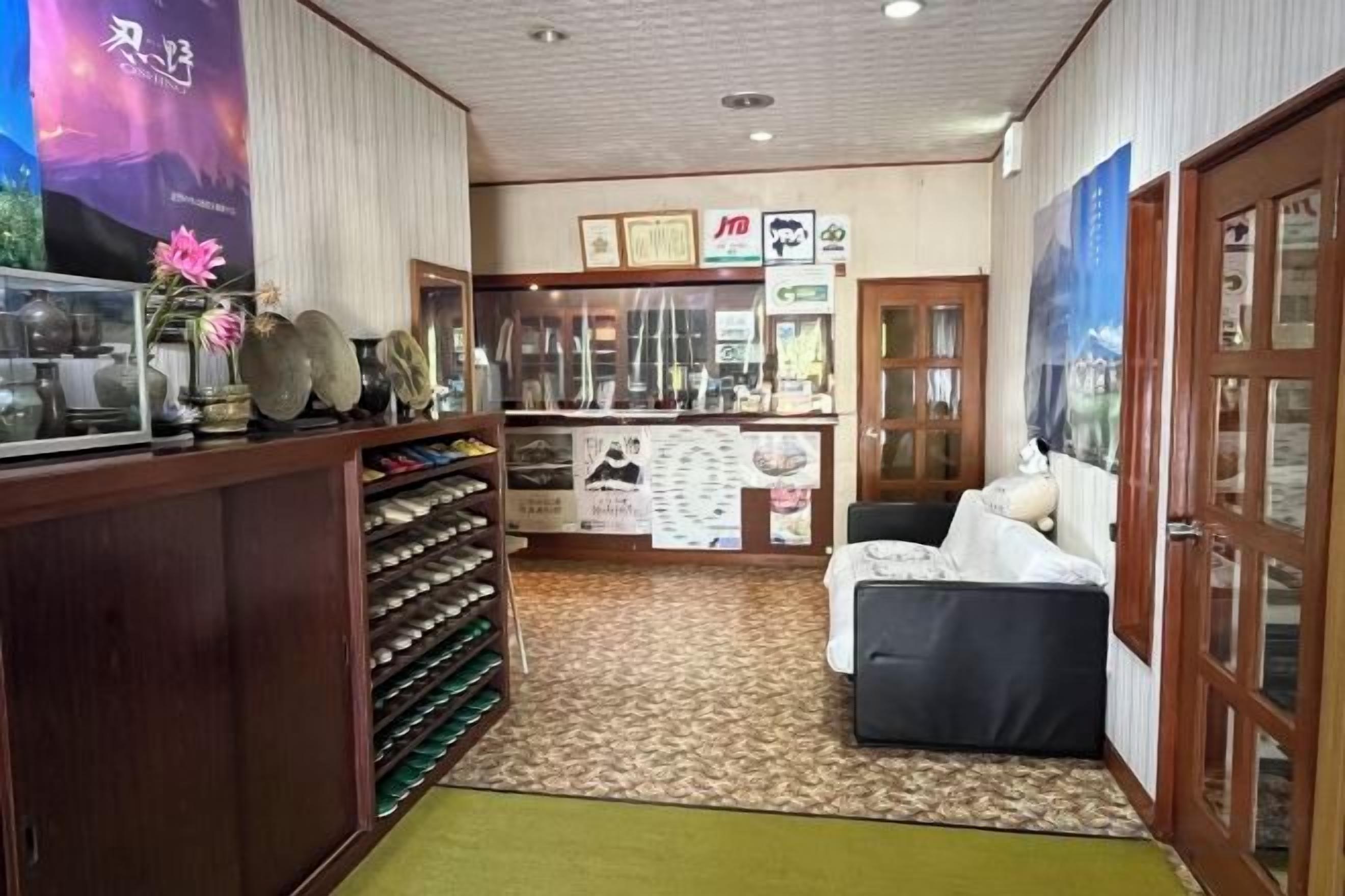 Una hall d'albergo con reception, area salotto e vetrina con servizi inclusi.