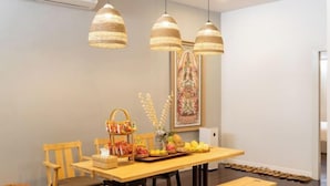 A dining area with a wooden table, chairs, and hanging woven light fixtures. - Good Moon at Tha Phae (Chiang Mai)