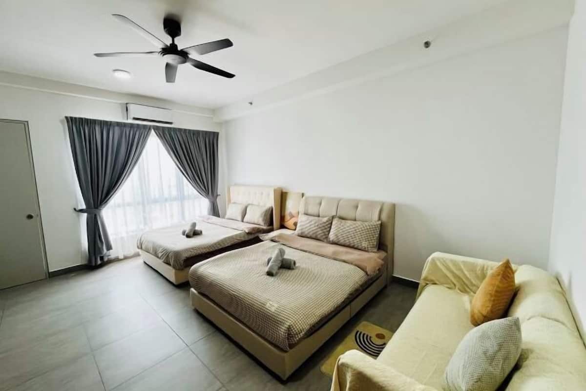Quarto com cama, sofá, ventoinha no teto e janela com cortinas.