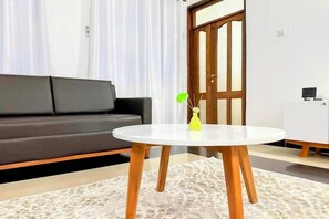 A modern living room with a sofa, a round table, and a cabinet. - Elrad Msamvu Villa with Privacy by Monalisa (Morogoro)