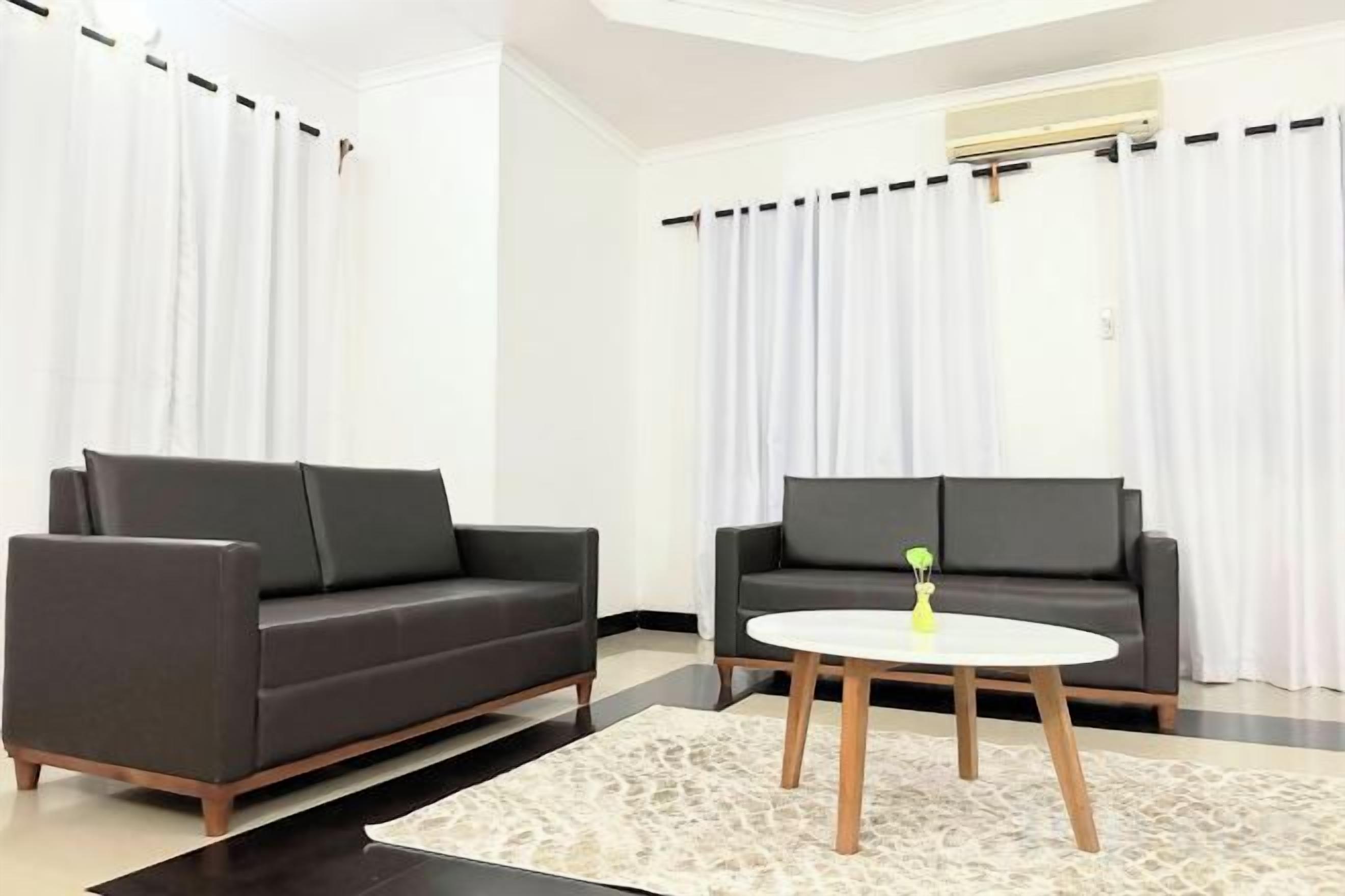 Un salon moderne avec deux canapés, une table basse et un tapis à motifs.
