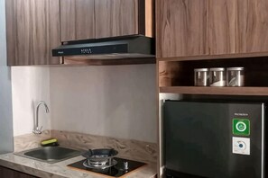 Una cocina con armarios de madera, un refrigerador de acero inoxidable y un lavamanos.