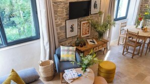 Ein Wohnzimmer mit einer Couch, einem Couchtisch und einem Essbereich mit Tisch und Stühlen.