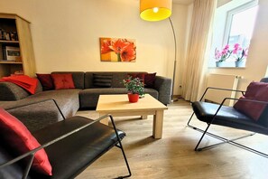 Ein modernes Wohnzimmer mit einer Couch, einem Couchtisch und einer Stehlampe.
