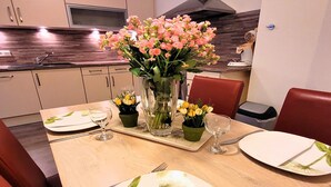 A dining table set with plates, cutlery, and a vase of flowers. - Bright Stay in Central Winterberg (Winterberg)