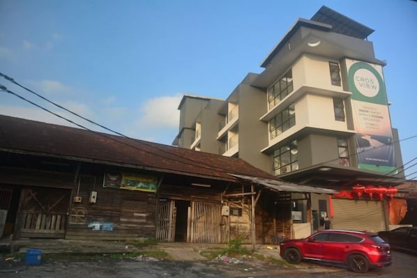 A building with a sign that reads 'CROSS VIEW' and a red car parked in front.
