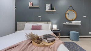 Une chambre moderne avec un lit, des tables de chevet, un miroir et des étagères murales.