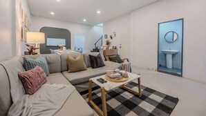 Un salon moderne avec un canapé, une table basse et une vue sur une salle de bain.