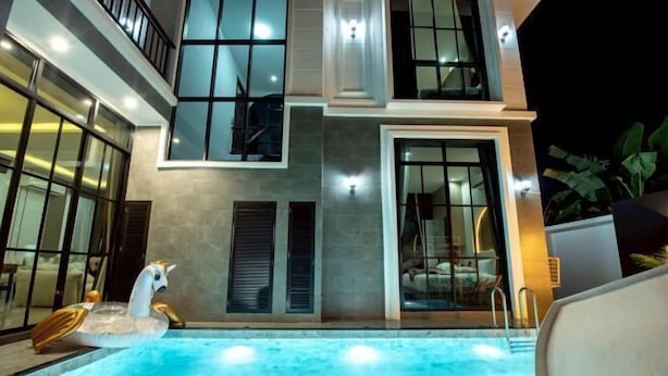 A modern building with a swimming pool, large windows, and a balcony. - Modern 3BR British Pool Villa + 5KM Jomtien Beach (Pattaya)
