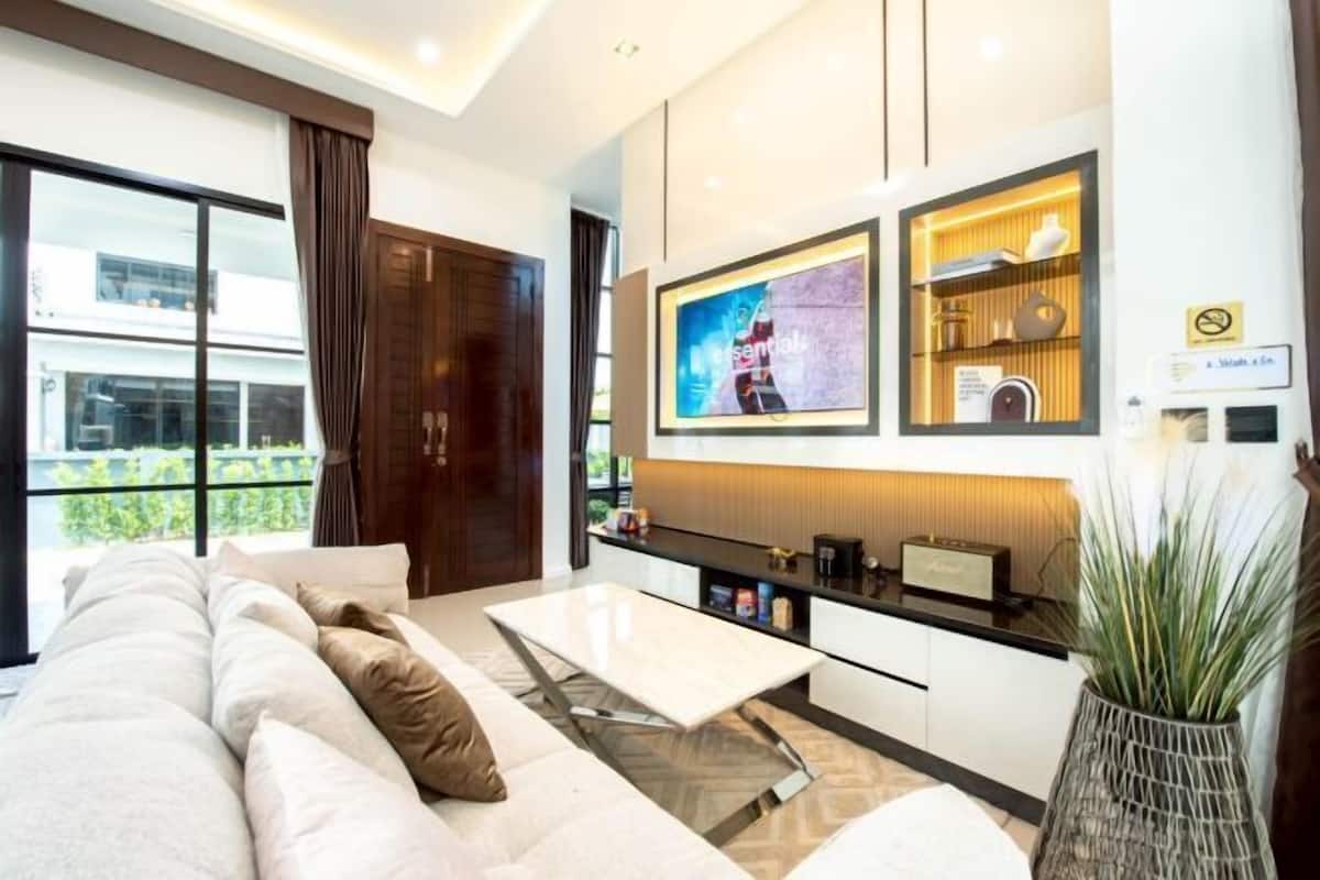 Un salon moderne avec un canapé, une table basse et un téléviseur fixé au mur.