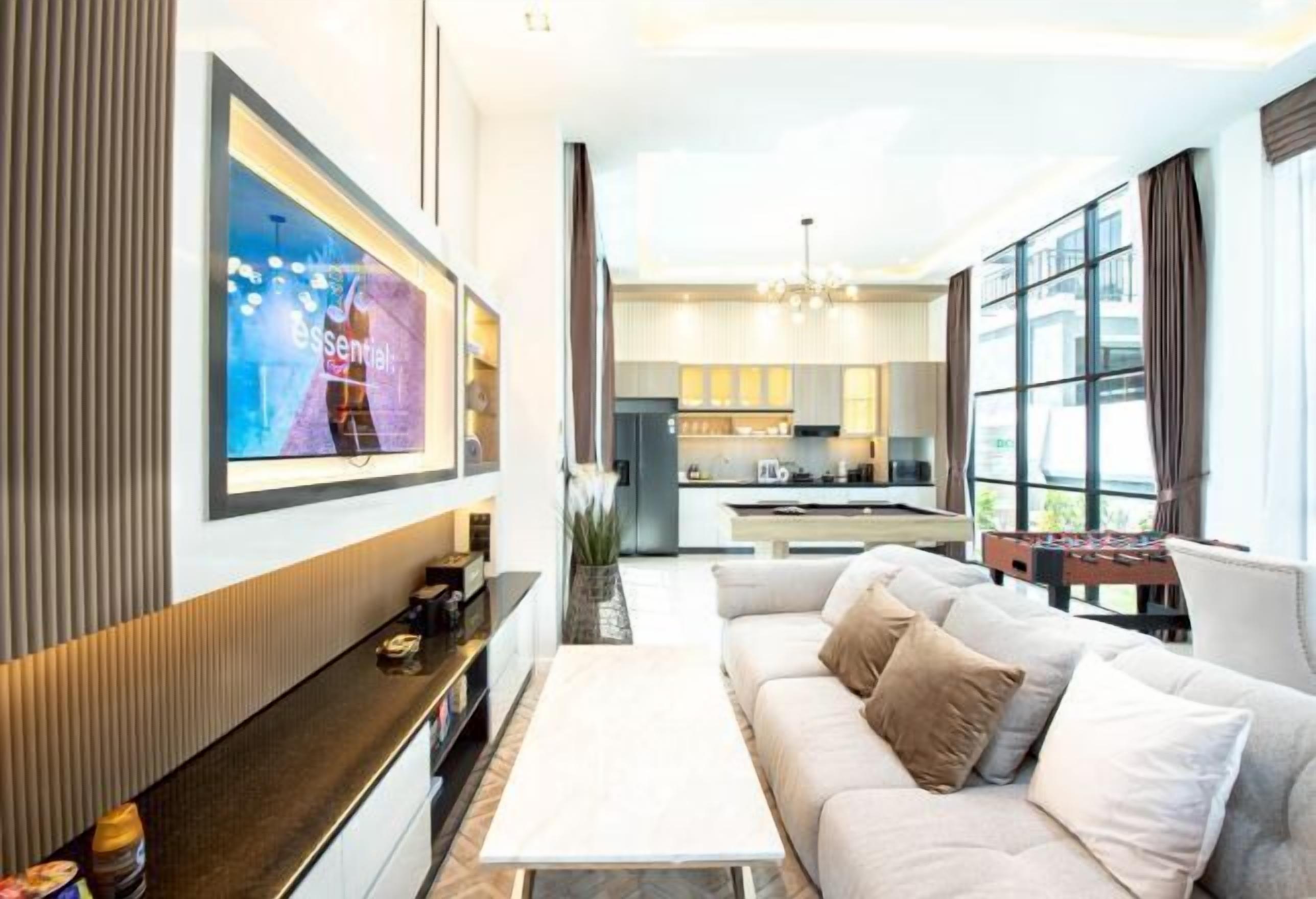 A modern living room with a sofa, a coffee table, and a TV mounted on the wall.