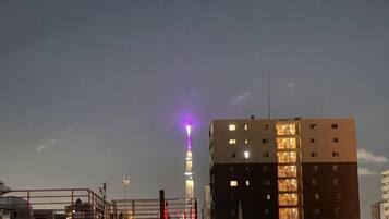 A building with multiple floors and a lit tower in the background.
