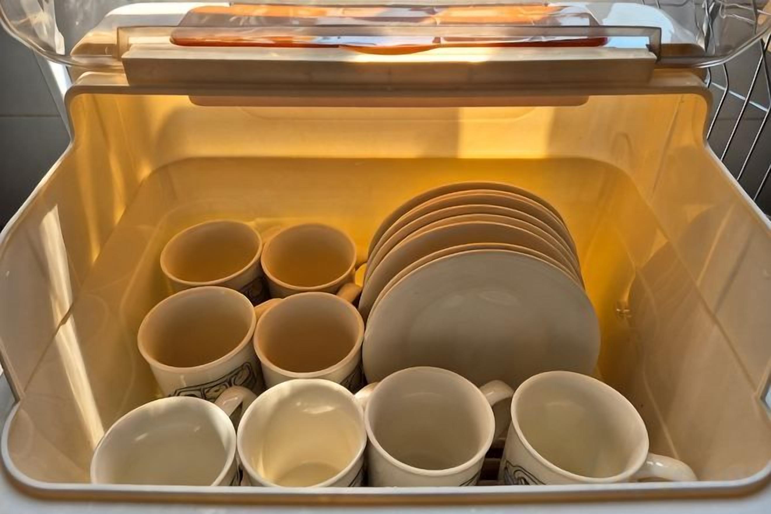A dishwasher with various dishes inside.