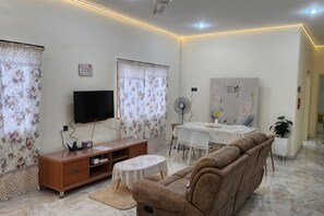 A living room with a sofa, TV, dining table, and curtains. - Ipoh Homestay Vacation 12 Pax 4 Bedroom for Delicious Food (Ipoh)
