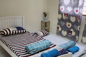 A bed with striped bedding, a bedside table with a plant, and a curtain with bear and heart patterns. - Ipoh Homestay Vacation 12 Pax 4 Bedroom for Delicious Food (Ipoh)
