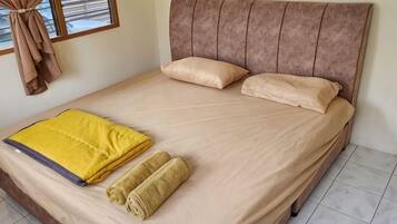 A bed with a headboard, pillows, and a blanket.
