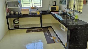 A kitchen with a microwave, sink, and cabinets.