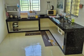A kitchen with a microwave, sink, and cabinets. - Ipoh Homestay Vacation 12 Pax 4 Bedroom for Delicious Food (Ipoh)