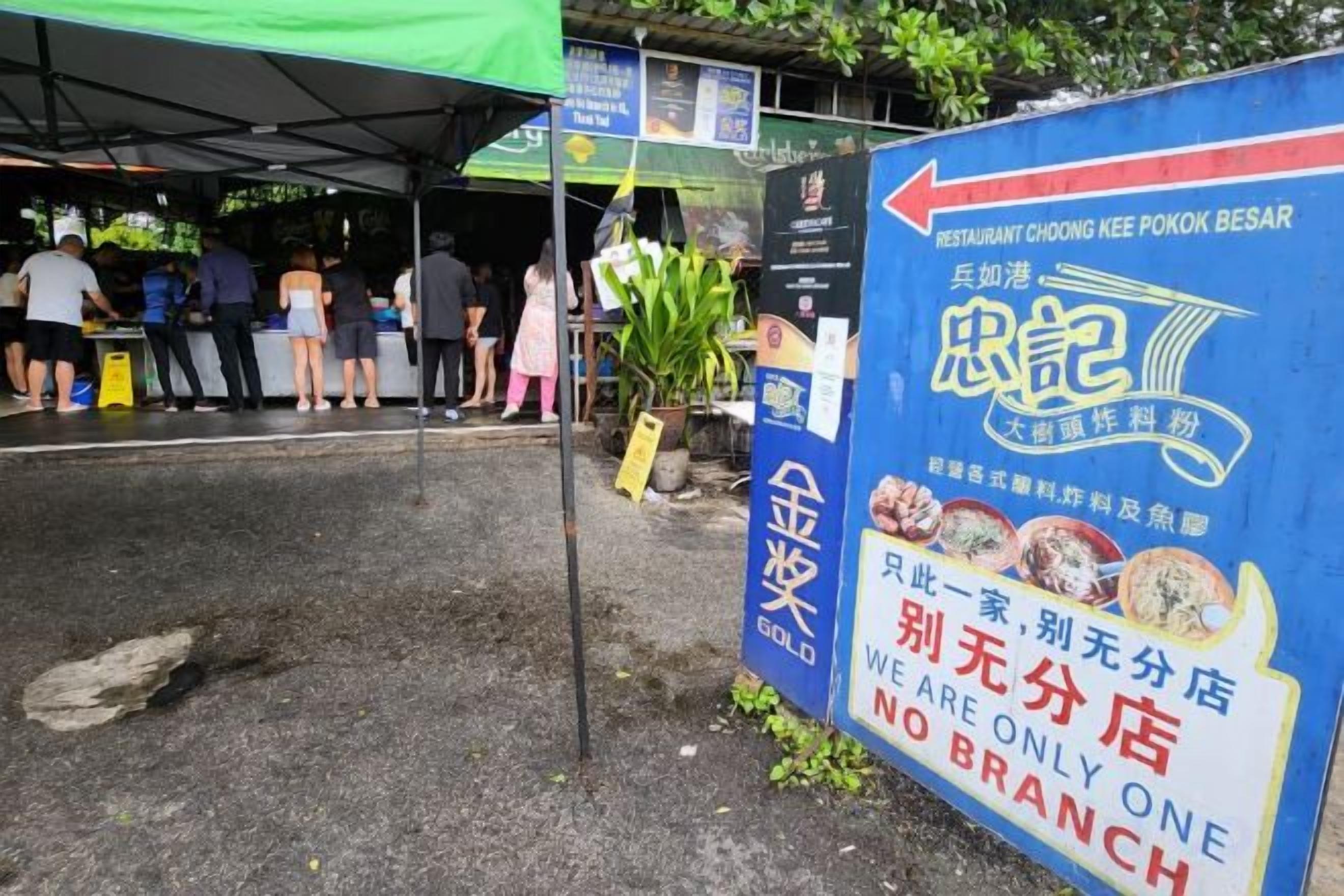 A restaurant sign with a blue background and white text, indicating a no-branch policy.