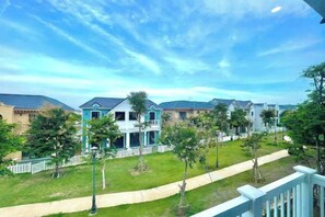 A residential area with houses, a pathway, and a clear sky. - Novaworld Phan Thiet - QT Villa (Phan Thiet)