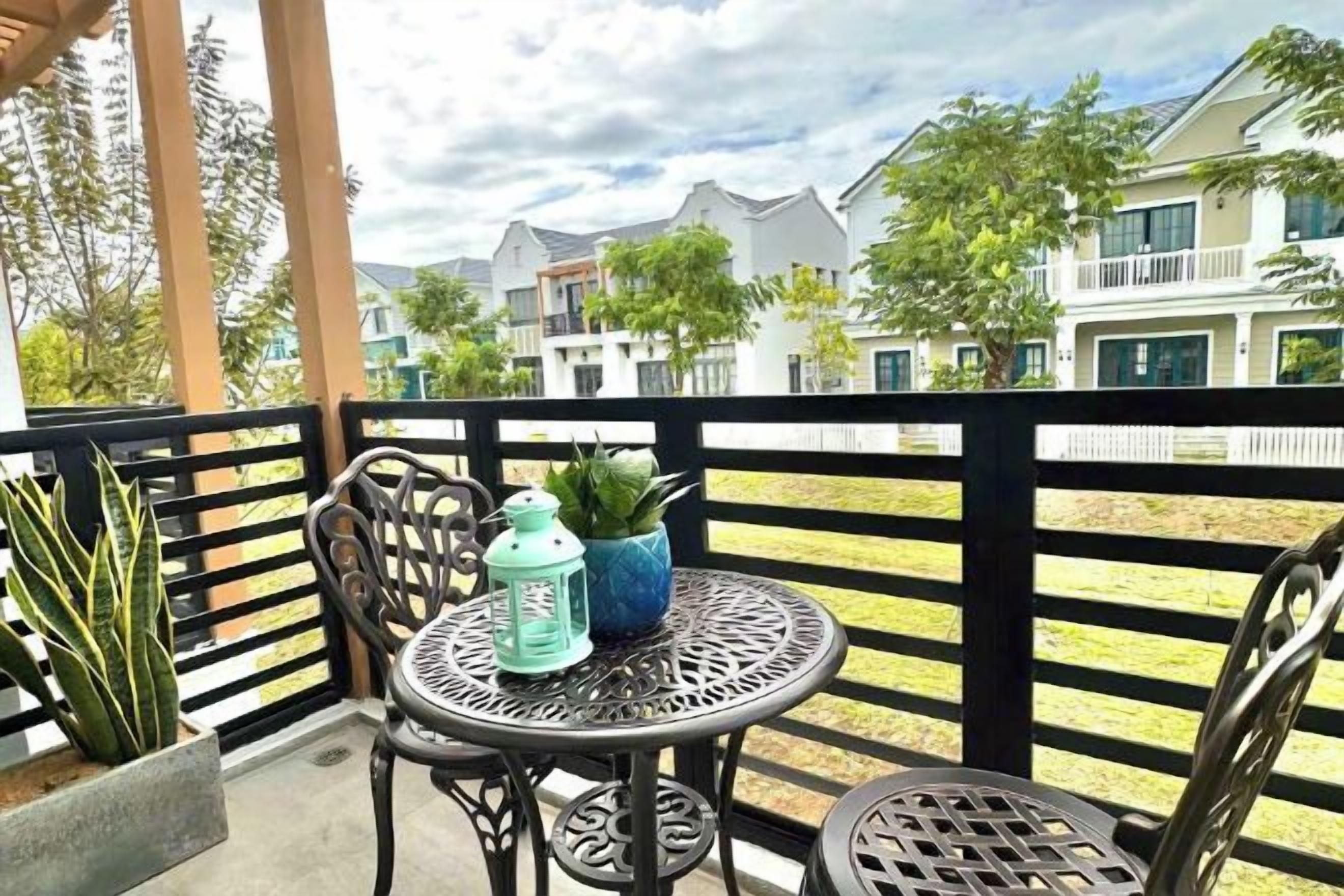 A balcony with two chairs, a small table, and a potted plant.