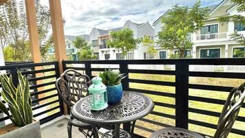 A balcony with two chairs, a small table, and a potted plant.