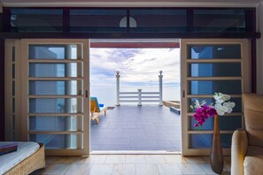 A room with a large open door leading to a balcony with a view of the sea and a white fence. - Oceanfront 6 Bedroom Twin Villas OV6 (Hua Hin)