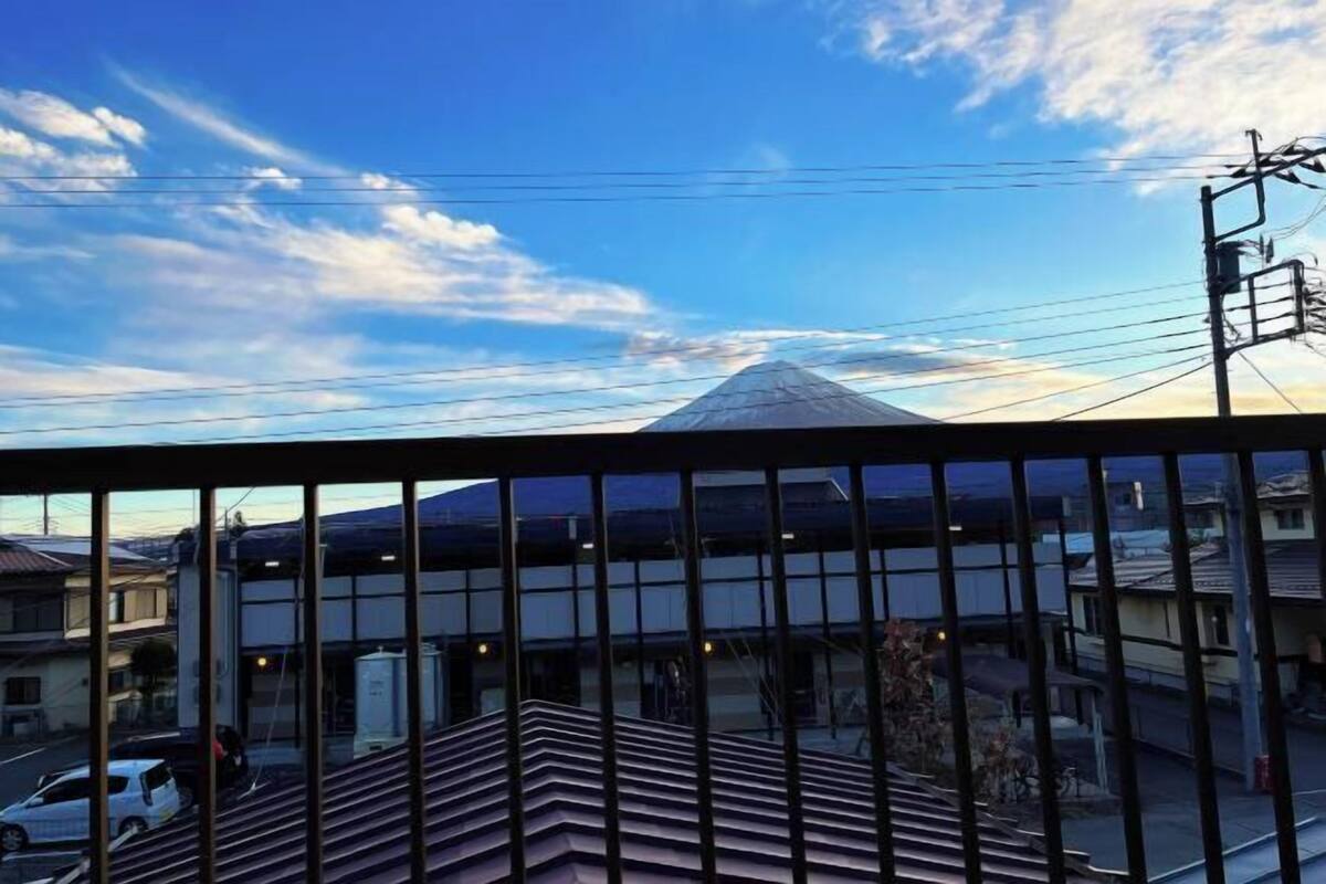 A building with a sloped roof, a clear sky, and power lines.