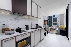 A modern kitchen with a marble countertop, a built-in oven, and a sink.