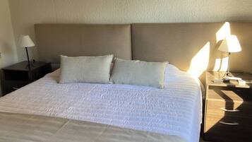 Tabla de planchar con plancha, internet y ropa de cama