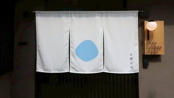 A white curtain with a blue circle and Japanese text hanging on a wall.