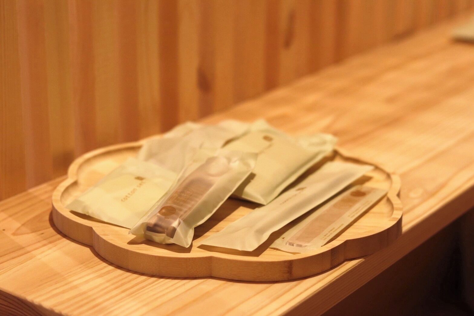 A wooden tray with several packaged items on a wooden bench.