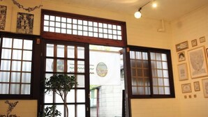 A traditional Japanese interior with sliding doors, framed artwork, and a potted plant. - Kitagatsukyo｜Direct train to Osaka Castle, Shinsaibashi, and Tsutenkaku (Osaka)