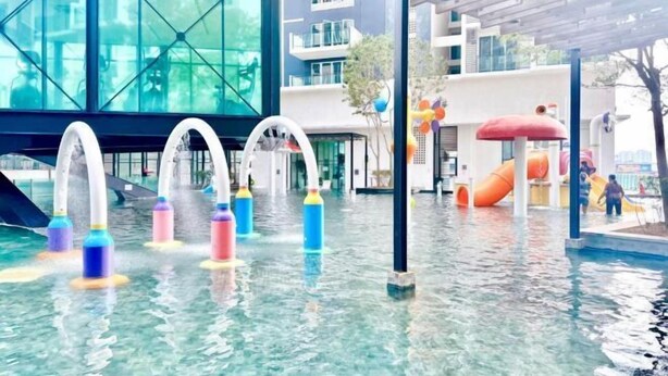 An indoor water play area with colorful water jets and slides.