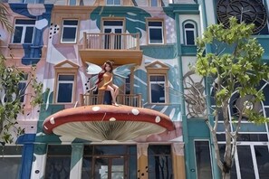 A building with a colorful facade, a balcony, and a large mushroom sculpture. - Longs Beach House Hồ Tràm - Beachfront Sea View Villa (Xuyen Moc District)
