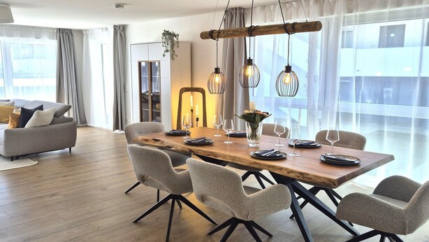 A modern dining area with a wooden table, six chairs, and hanging pendant lights. - Winterberg comfort for 4 guests (Winterberg)