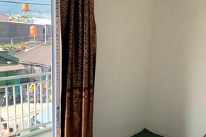 Une pièce avec une fenêtre donnant sur un balcon.