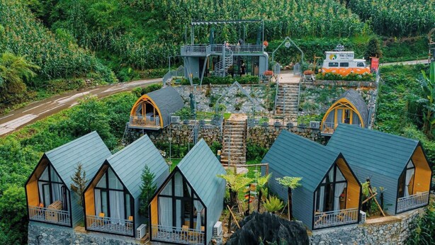 A hillside retreat with multiple cabins featuring large windows and stone foundations. - The Chill Garden Sapa (Ta Van)