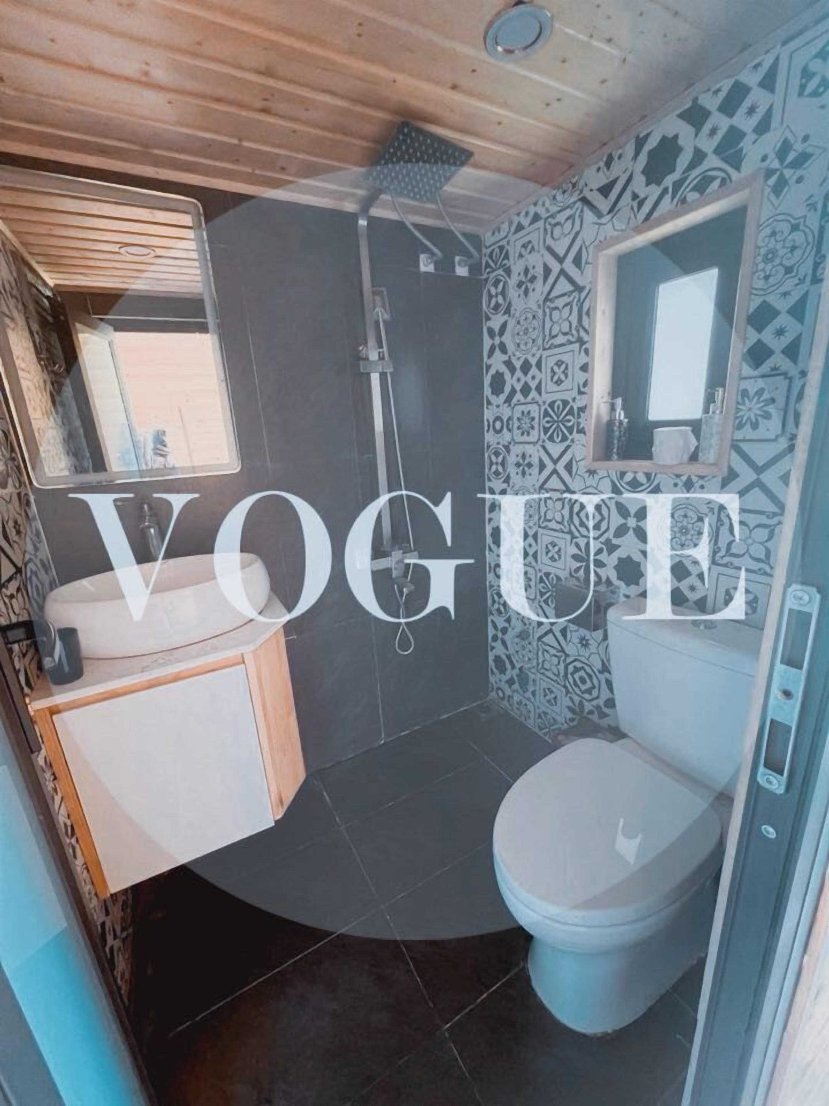 A bathroom with a shower, toilet, and sink.
