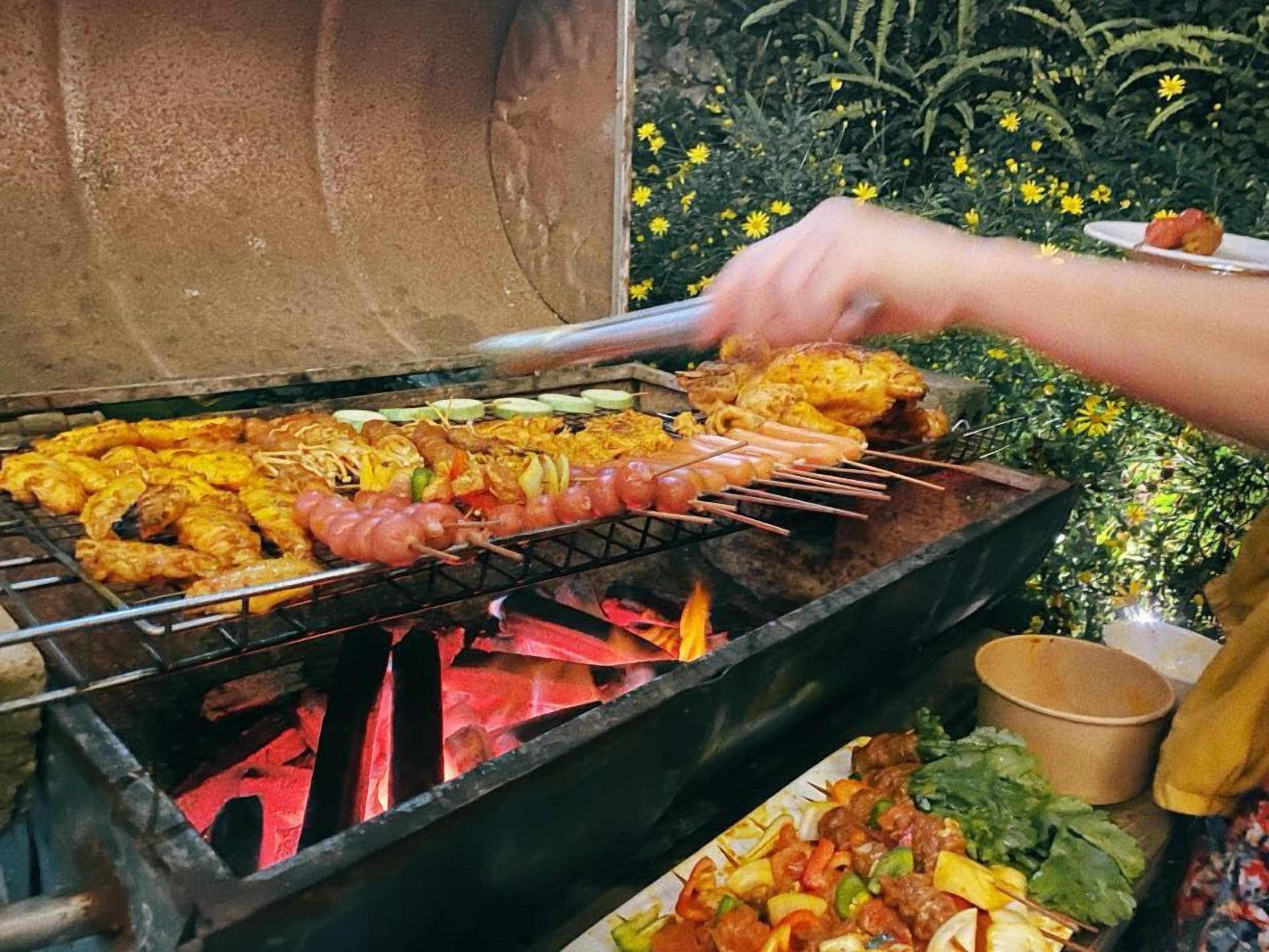 A grill with various meats and vegetables being cooked.