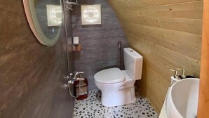 A small, sloped bathroom with a toilet, bidet, and sink. - The Chill Garden Sapa (Ta Van)