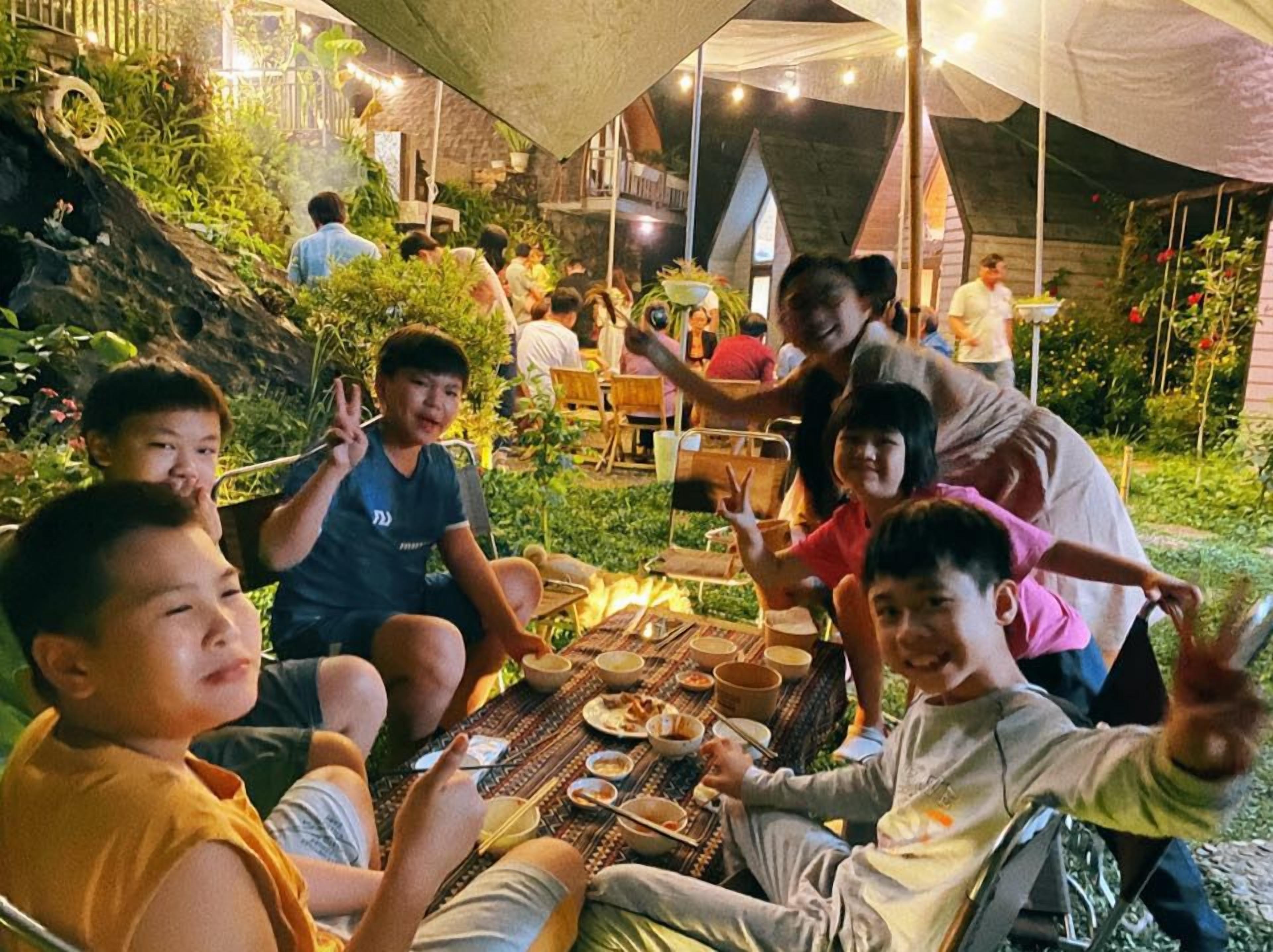 Un grupo de personas sentadas alrededor de una mesa al aire libre, quizás en un restaurante o café.
