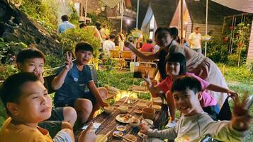 Un grupo de personas sentadas alrededor de una mesa al aire libre, quizás en un restaurante o café.