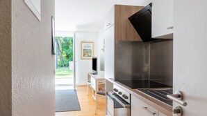 A modern kitchen with a built-in stove, oven, and a large black grill.