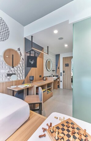 A modern bedroom with a bed, a desk, a mirror, and a chessboard. - lyf Farrer Park Singapore (Singapore)